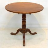 A Georgian mahogany single pedestal tilt top table, raised on tripod legs.