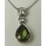 A white 18ct gold, peridot and diamond pendant and chain, the pear cut peridot of approximately 9.