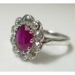 An 18ct white gold, diamond and ruby dress ring, the oval cut ruby of approximately 8.2 by 5.