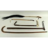 A group of five vintage sticks and riding crops, one of turned oak with leather loop attached,