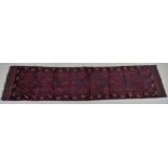 A Meshwani runner rug, with dark red and dark blue ground, six diamond pendants,