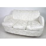 An early to mid twentieth century Art Deco style two seater sofa, with tall stepped curved back,