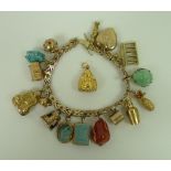 A 14ct gold wishbone gatelink charm bracelet, with sixteen charms and an additional loose charm,