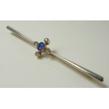 A 15ct gold and platinum bar brooch, set with an oval sapphire surrounded by four small diamonds,