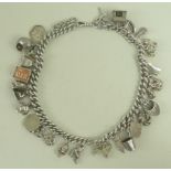 A silver charm bracelet with twenty six charms including a rocking horse, lion, shell,