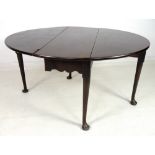 An early Georgian mahogany drop leaf table, with oval surface and kick leg action,