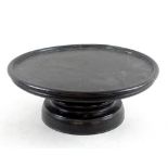 An Irish bog oak lazy Susan, ebonised, raised on a turned base, 31.5cm diameter.