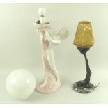 A pair of Art Deco style lamps, one a model of a nude supporting an amber globe with her feet,