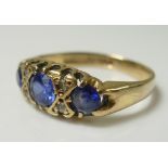 A 9ct gold dress ring, set with three cornflower blue stones,