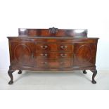 An Edwardian mahogany bowfront sideboard, gallery back carved with central crest, gadrooned edging,