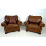 A pair of modern John Lewis armchairs, each upholstered in brown leather,