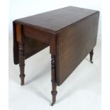 A 19th century mahogany drop leaf table, raised on turned supports with brass castors,