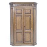 An early Victorian oak, mahogany crossbanded and ebony strung, corner cupboard,