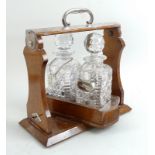 An oak and silver plated tantalus, with swivel mechanism,