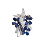 A sapphire and diamond set pendant brooch, designed as a floral and foliate spray,