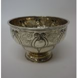 A silver bowl of circular form, engraved with floral sprays alternating with feathered scrolls,
