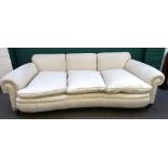 A late 19th century cream upholstered sofa, with concave seat and roll over arms,