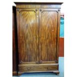 A George IV mahogany wardrobe, the pair of shaped panel doors over one long drawer,