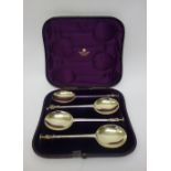 A set of four Victorian silver serving spoons, each with a differing figure terminal,