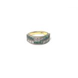 A gold, emerald and diamond ring, mounted with rows of three square cut emeralds,