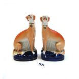A pair of Staffordshire pottery models of seated greyhounds, mid 19th century,
