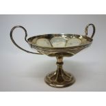 A silver twin handled tazza dish, with panelled decoration, raised on a swept circular foot,