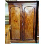 An early Victorian mahogany two door wardrobe, with fitted interior, on a plinth base,