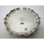 A silver salver of shaped circular form, having a pie crust rim, in the Chippendale style,