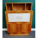 A mid 20th century satin birch secretaire with three open pigeon holes above a vellum fall front