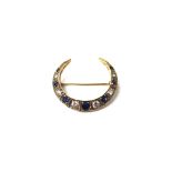 A 9ct gold, sapphire and diamond brooch, designed as a crescent,