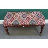 An oak framed footstool, with serpentine short ends on turned fluted supports,