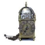 A brass lantern clock, the bell over a posted frame, the dial engraved with a Tudor rose,