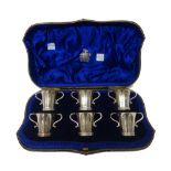 A set of six silver twin handled spirit tots, each initial engraved, London 1904,