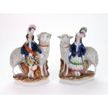 A pair of Staffordshire highland figures standing before frit decorated sheep, 20.5cm high.
