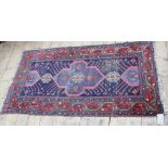 A North West Persian rug, the blue field with light blue lobed medallion and red meander border,