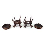 A pair of Chinese rosewood vase stands, late 19th/early 20th century, with four scrolled supports,
