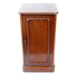 A Victorian mahogany pot cupboard, circa 1860, enclosed by a panelled door, on a plinth base,