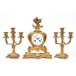 A Louis XV style gilt metal cased mantel clock and pair of matching four branch candelabrum,