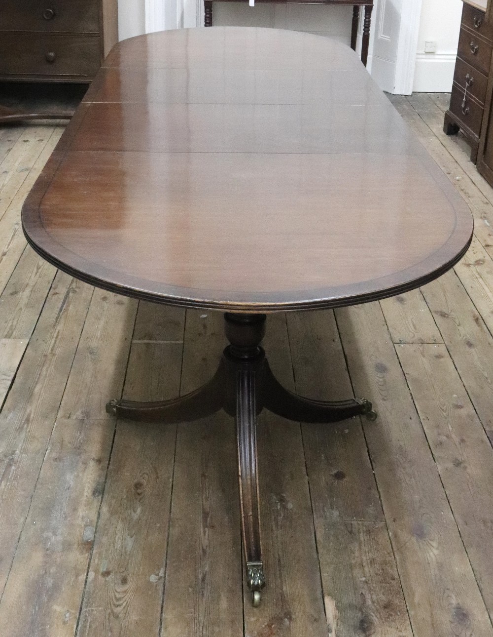 A reproduction Regency style mahogany ebony strung 'D' end dining table,