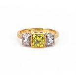 A three-stone diamond ring, the central intense yellow princess cut stone approx. 1.
