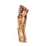 A Chinese ivory figure of a woman, late 19th/early 20th century carved standing in long robes,
