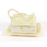 A Belleek butter dish in the form of a thatched cottage, 16.5cm wide.