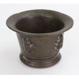 A bronze mortar, 17th/18th century, with wide rim, the sides decorated with masks,