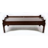A butler's style reproduction mahogany low table, the tray top with arched cut-out carrying handles,