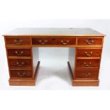 A reproduction yew wood pedestal desk, with inset top above three frieze and four pedestal drawers,