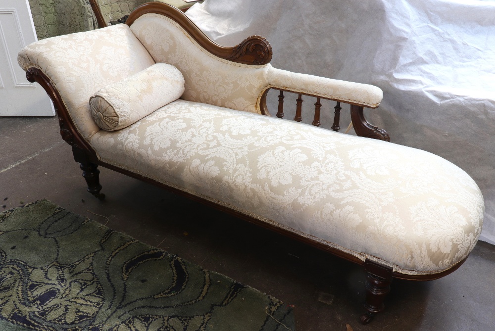 A Victorian foliate carved mahogany frame chaise longue, circa 1870, with a shaped upholstered back,