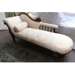 A Victorian foliate carved mahogany frame chaise longue, circa 1870, with a shaped upholstered back,