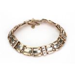 A yellow metal and diamond set gate-link bracelet,