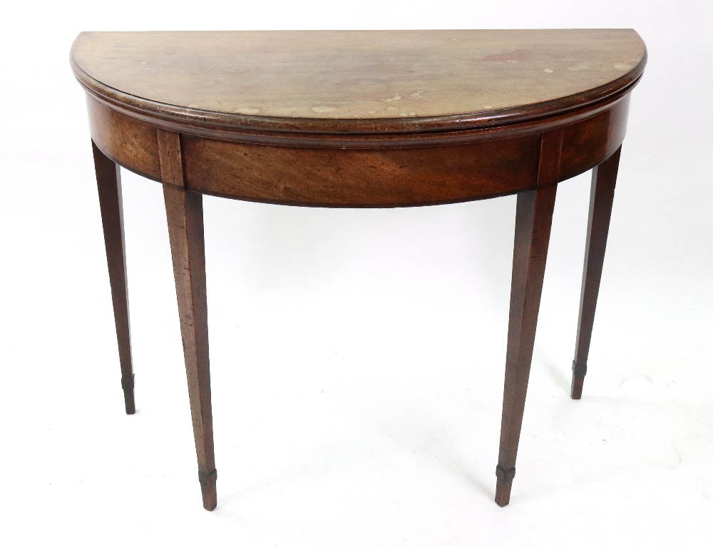 A George III mahogany tea table, with hinged demi lune fold over top, on square tapered legs,