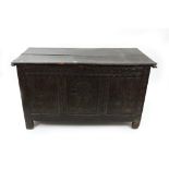 A late 17th century carved oak coffer, of panelled construction, with hinged top,